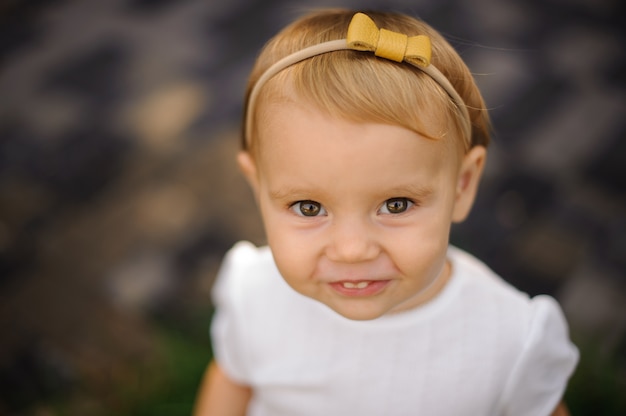 Cute baby girl in a yellow bow