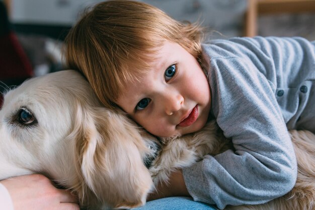 Foto bimbo carino e il suo labrador retriever a casa sul letto