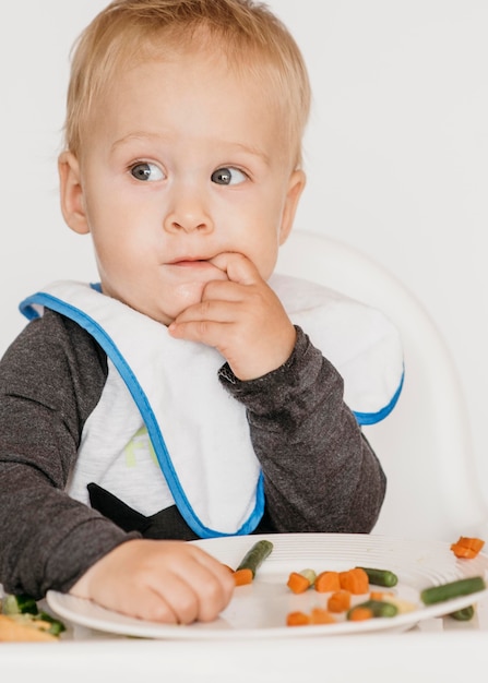 写真 一人で食べるハイチェアのかわいい赤ちゃん