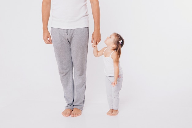 Cute baby learning to walk and make his first steps. mom is holding his hand. child's feet close up, copy space