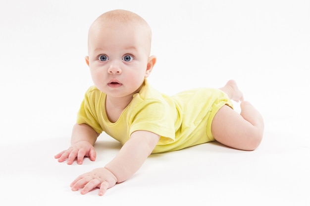 Bambino sveglio che si trova sullo sfondo e sorridente