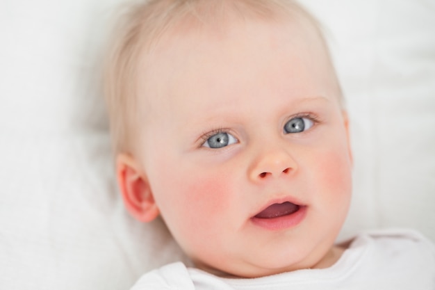 Cute baby lying while opening her mouth