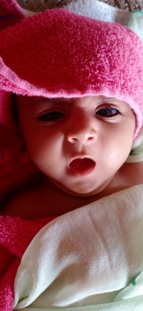 Cute baby in a pink towel new burn baby