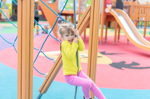 Foto bambino carino che gioca e si arrampica nel parco giochi