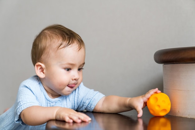 Cute baby playing with ball on the stairs Baby boy playing with colorful toy