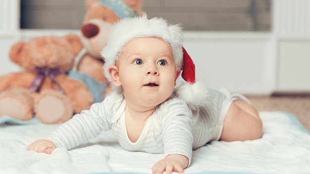 Cute baby in santas hat on christmas eve