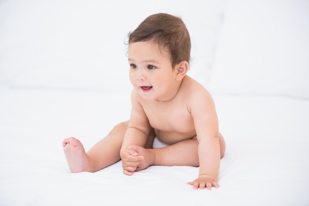 Cute baby sitting on bed