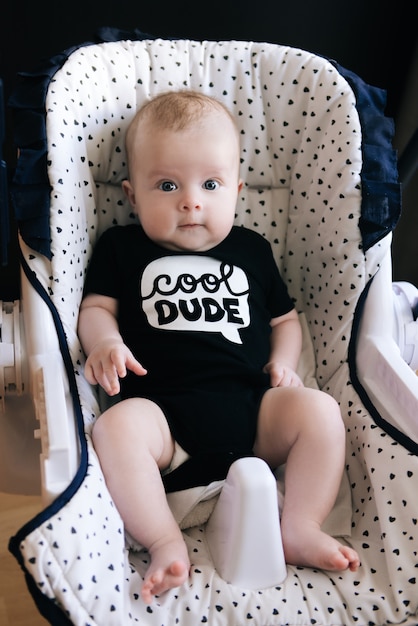 Photo cute baby sitting in a high chair, swings