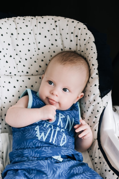 Cute baby sitting in a high chair, swings