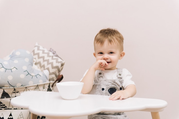 Cute baby sitting at the table and eating