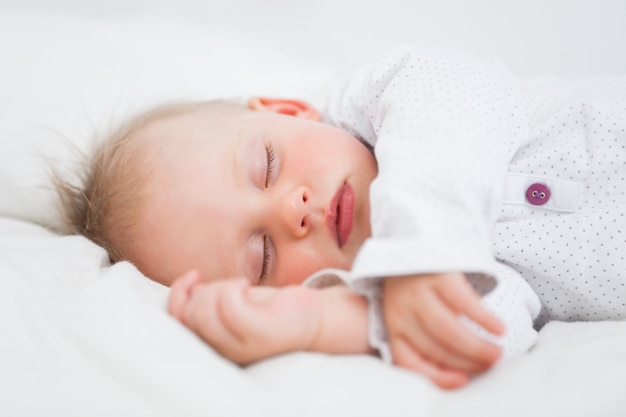 Cute baby sleeping while extending her arms