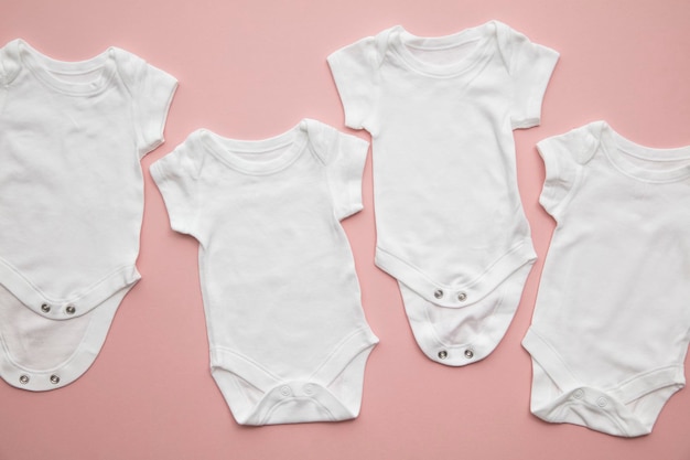 Photo cute baby white body suit layout on a pastel pink background