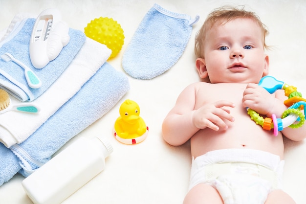 Cute baby with bath accessories in the bed