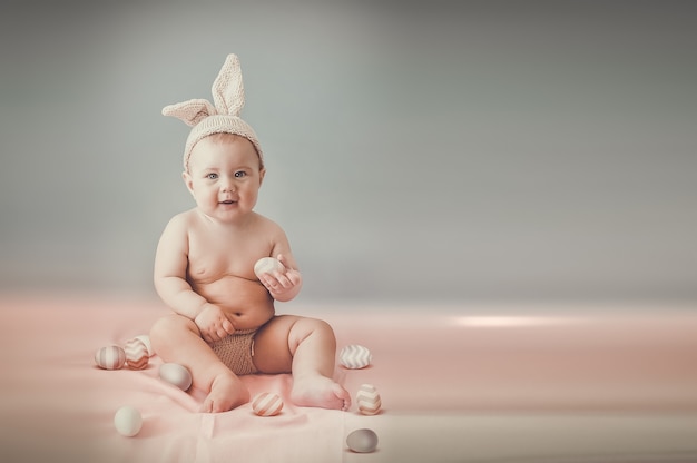 Cute baby with colorful easter eggs - a beautiful holiday card