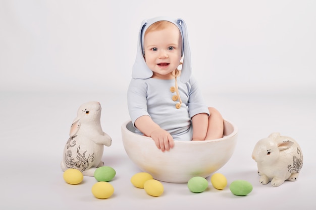 Cute baby with painted Easter eggs and bunnies