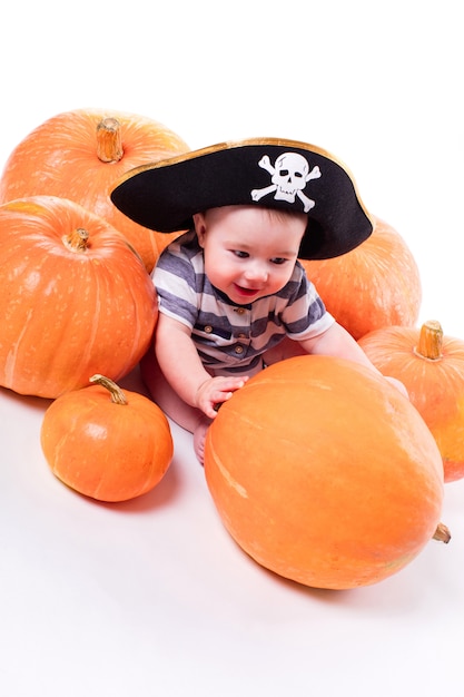 Cute baby with a pirate hat on his head lying on his stomach on 