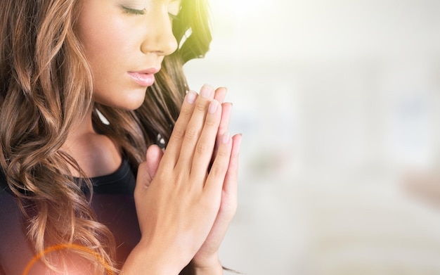 Cute beautiful girl folded her hands in prayer asks God for help