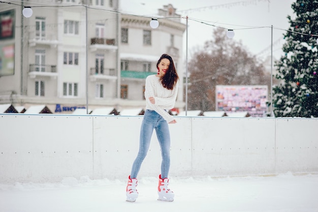 Cute and beautiful girl in a white sweater in a winter city