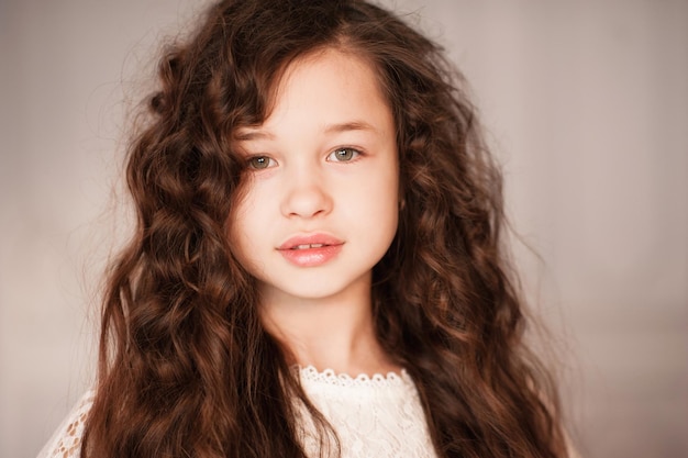 Cute beautiful kid girl with long dark blonde hair in room close up Portrait of young teenager