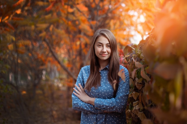 Cute beautiful smile woman walking in red autumn park