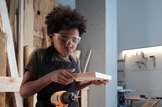 Cute black boy in workshop