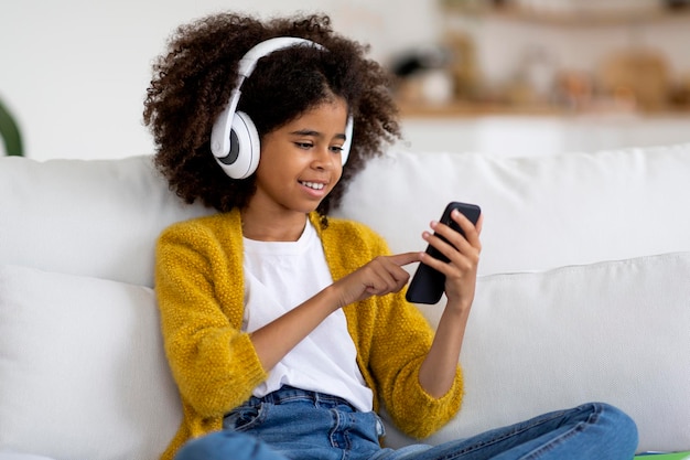 Cute black child watching video on Internet home interior