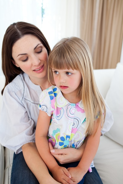 Cute blond girl sitting on her mother's lap