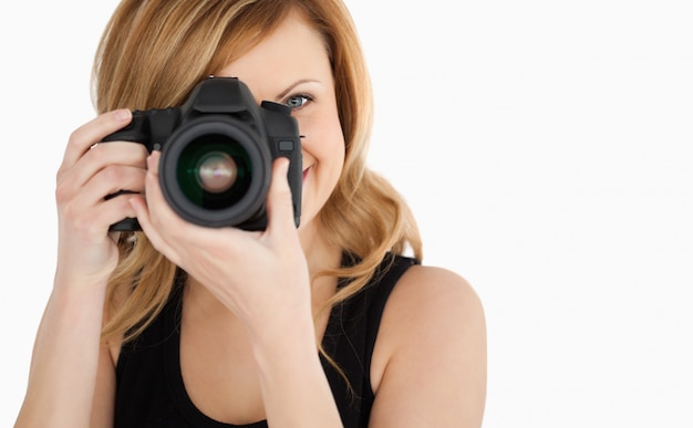 Carina donna dai capelli biondi, scattare una foto con una macchina fotografica