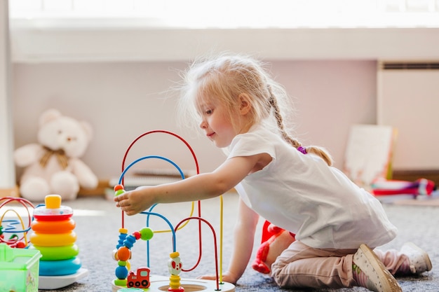 写真 かわいいブロンドの女の子が床で遊んで