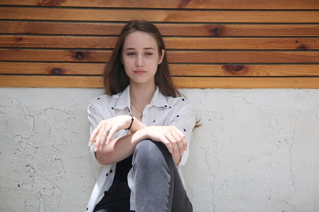 Cute blonde girl sitting on floor and looking away