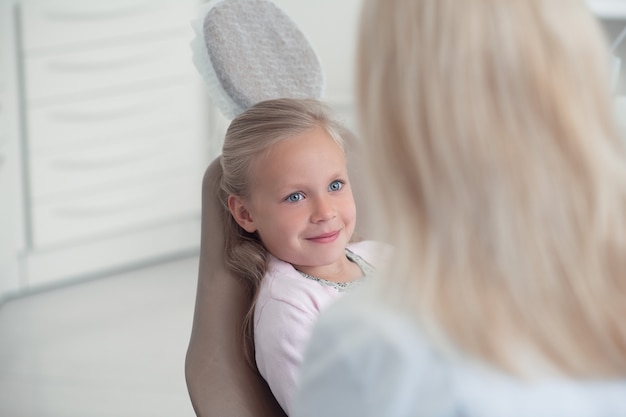 Cute blonde girl waiting for the examination at the dentists