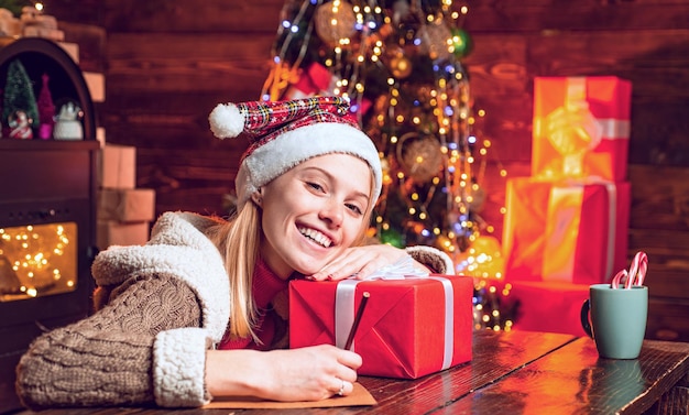 Cute blonde woman with christmas gift girl celebrating noel party