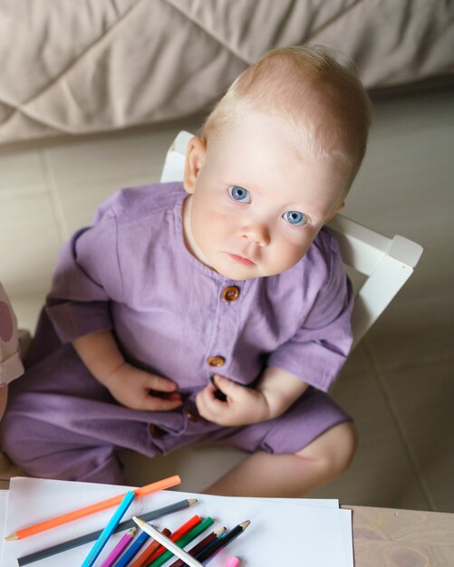 Cute blue eyed baby boy with golden hair while playing at home