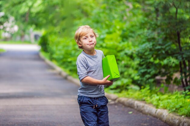 Ragazzo carino porta una confezione regalo fai regali e concetto di consegna