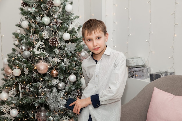 Cute boy at the Christmas tree, New Year's concept