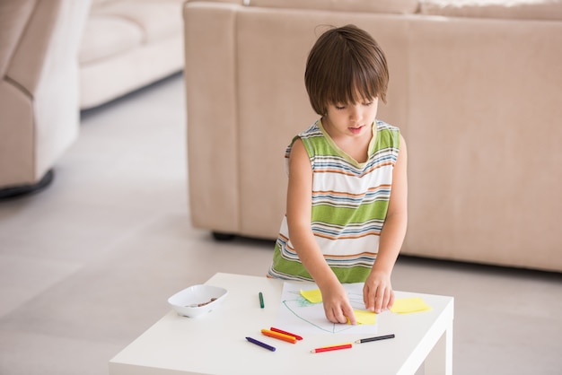 Симпатичный мальчик рисует дома