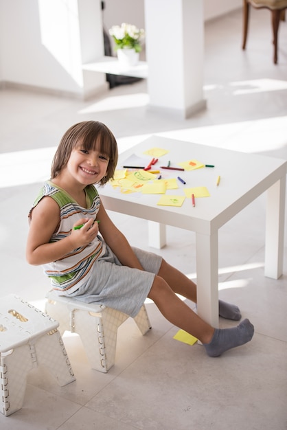 Cute boy drawing at home