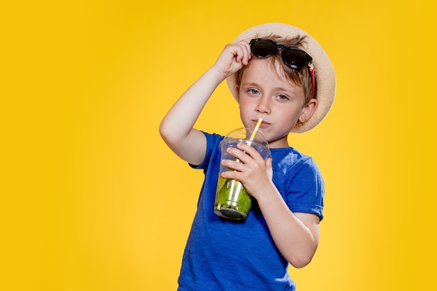 Ragazzo carino bere cocktail mojito dal bicchiere di plastica.