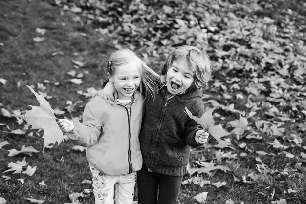 Cute boy and girl little couple walking on autumn park child friendship and kindness kids love