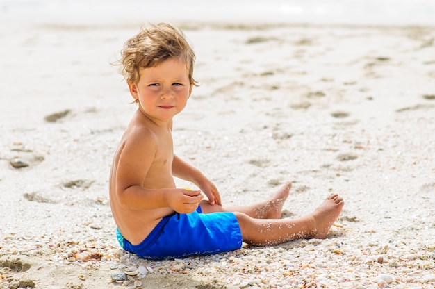 ビーチで楽しんでいるかわいい男の子。