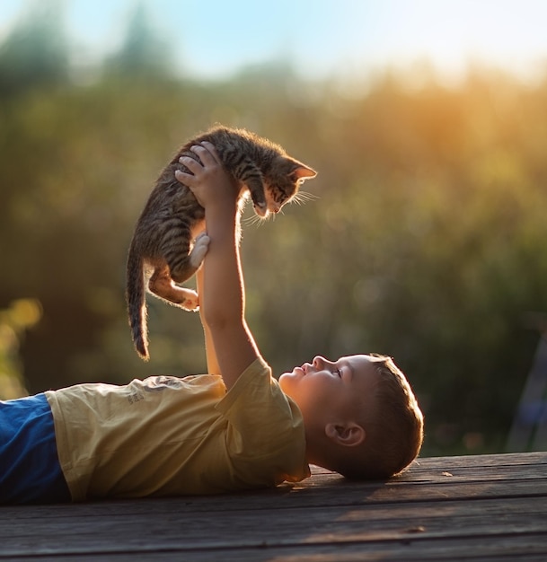 写真 子猫を手に持ったかわいい男の子