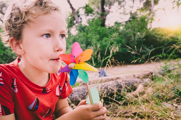 Photo cute boy holding pinwheel toy