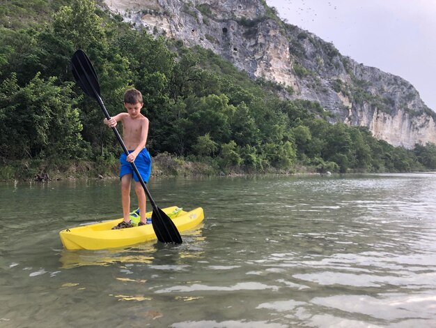 Un ragazzo carino in kayak sul lago.