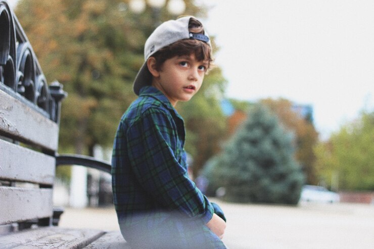 Photo ベンチに座っている可愛い男の子が目をそらしている