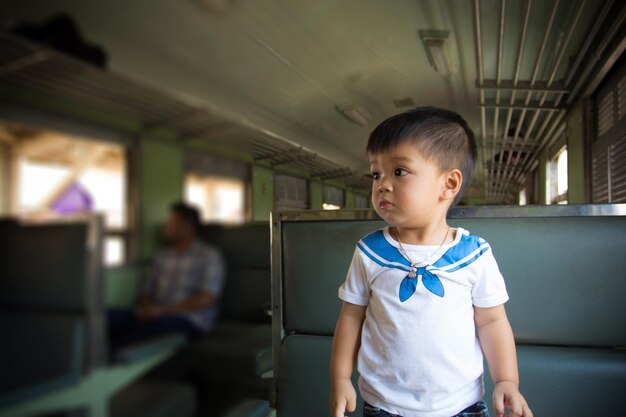 Foto ragazzo carino che guarda lontano mentre è in piedi nell'autobus