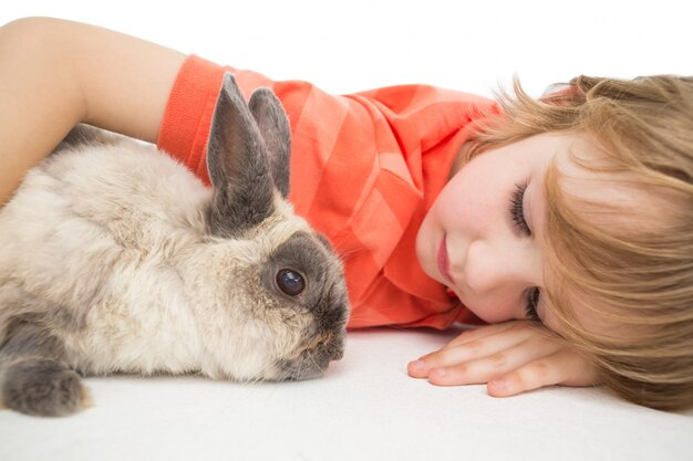 Cute boy lying arm around bunny