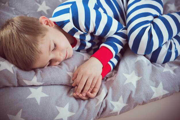 Photo cute boy lying on bed