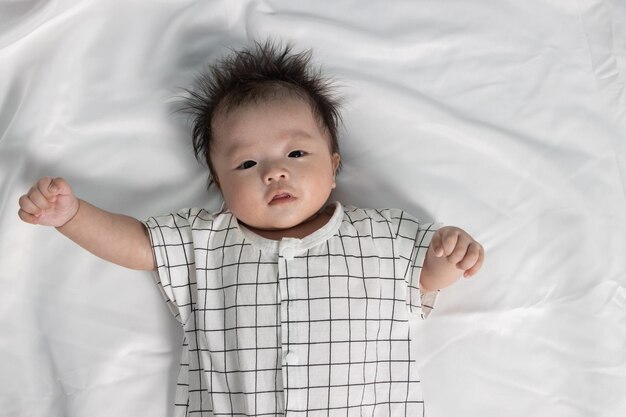 Photo cute boy lying on bed