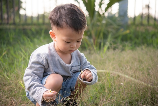 Photo cute boy picking grass