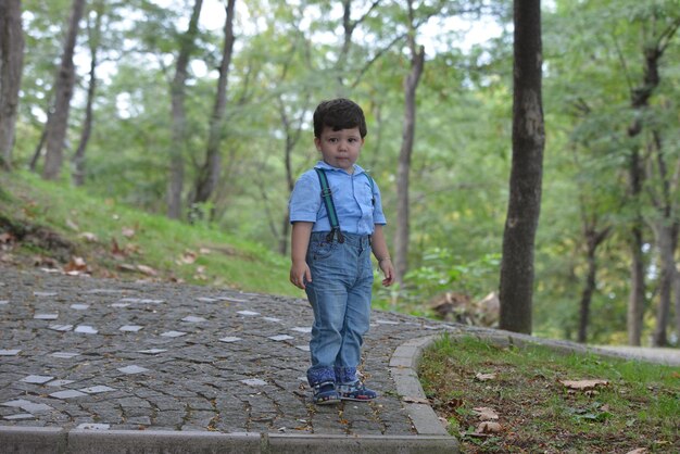 Photo cute boy playing at public park during autumn